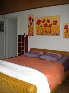 a bedroom with two beds and two paintings on the wall at Appartement La Coudraie in Blonay