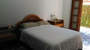 Schlafzimmer mit einem Bett, einem Tisch und einem Fenster in der Unterkunft Casa Condominio Escarpas do Lago em Capitólio MG in Capitólio