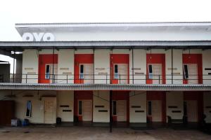 an empty building with red doors and a balcony at SUPER OYO 811 Mars Kost Syariah in Jambi
