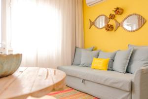 sala de estar con sofá y pared amarilla en Iris Apartment - Home Dream en Nazaré