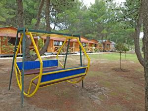 a yellow and blue swing in a park at Saranda Beach Bungalow in Ulcinj