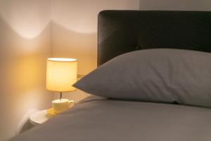- un lit avec un oreiller et une lampe à côté dans l'établissement Mariva Downtown Studio, à Rovinj