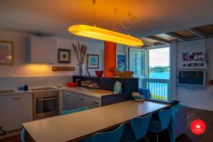 una cocina con mesa y algunas sillas azules en La casa dagli occhi blu, en Portovenere