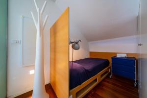 a small bedroom with a bed and a lamp at La Casa dagli Occhi Blu in Portovenere