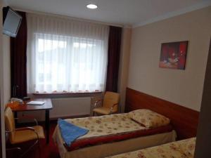 1 Schlafzimmer mit 2 Betten, einem Tisch und einem Fenster in der Unterkunft Motel Boczów-Polmax in Boczów