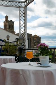 a table with a glass of orange juice on top of it at Hotel El Convento in Arcos de la Frontera