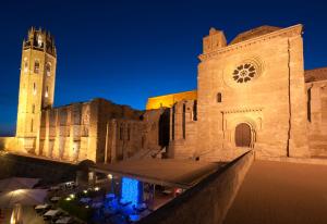 duży budynek z wieżą zegarową i kościołem w obiekcie Ibis Lleida w mieście Lleida