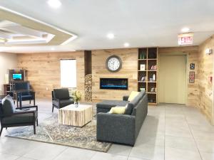 a lobby with a couch and chairs and a clock at Country Inn & Suites by Radisson, Greenville, NC in Winterville