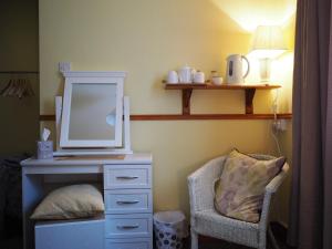 1 dormitorio con tocador con espejo y silla en Inglewood Lodge B&B en Naas