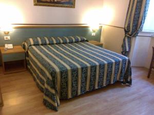 a bedroom with a bed with a blue and green blanket at Hotel Lazzari in Rome