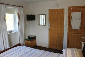 a bedroom with a bed and a wooden door at Aviedale Suite in Gorseness