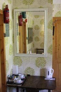 um espelho numa parede com uma mesa num quarto em Aviedale Suite em Gorseness