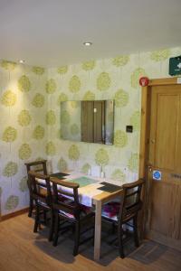 a dining room table with chairs and a mirror on the wall at Aviedale Suite in Gorseness