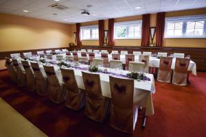 a conference room with tables and chairs with flowers on them at Hotel Ryšavý in Vémyslice