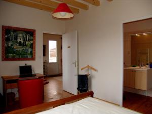 a bedroom with a bed and a desk and a table at LA VIGNERAIE in Fuissé