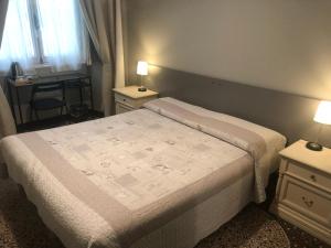 A bed or beds in a room at Check-Inn Rooms Genova Centro