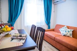 un soggiorno con divano e tavolo di Guest House S-Lux a Petrovac na Moru