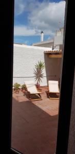 dwa leżaki na patio obok ściany w obiekcie Casa Isabella w mieście Calasetta
