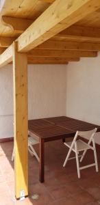 a wooden picnic table under a wooden roof at Casa Isabella in Calasetta