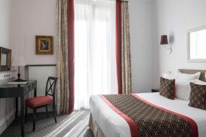 a hotel room with a bed and a desk and a window at Bradford Elysées - Astotel in Paris