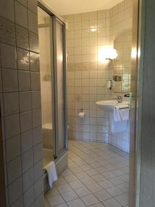 a bathroom with a sink and a shower at Landhaus Hotel Göke in Hövelhof