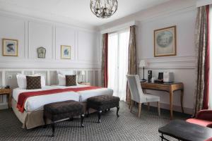 a hotel room with a large bed and a desk at Bradford Elys&eacute;es - Astotel in Paris