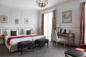 una camera d'albergo con un grande letto e una scrivania di Bradford Elysées - Astotel a Parigi