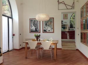a dining room with a table and white chairs at Montalcino Loft in Montalcino +4 photos