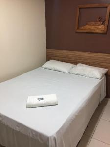 um quarto de hotel com uma cama com uma toalha em Pousada Do Sol Ponta Verde em Maceió