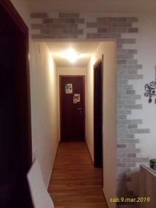 korytarz z ceglaną ścianą obok drzwi w obiekcie APPARTAMENTO DOGANA FIUMALBO w mieście Fiumalbo