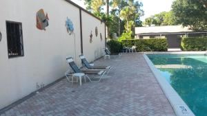 un patio con sillas y una piscina en Road Runner Travel Resort, en Fort Pierce