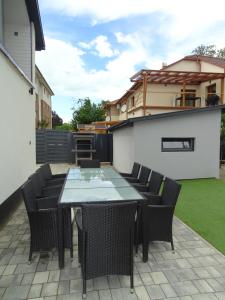 een patio met een tafel en stoelen in de achtertuin bij Dorothy 2 in Siófok