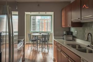 eine Küche mit einem Tisch und Stühlen sowie einem Fenster in der Unterkunft ENVITAE 3BR Downtown Luxurious Suite Views & Pool in Chicago