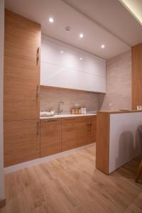 a kitchen with wooden cabinets and a sink at Hotel Vela in Budva