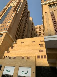 a building in front of some tall buildings at Altelal Apartment in Mecca