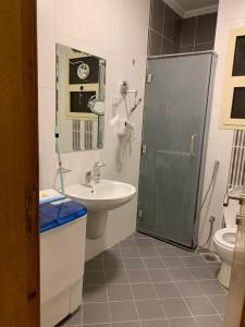 a bathroom with a shower and a sink and a toilet at Altelal Apartment in Makkah