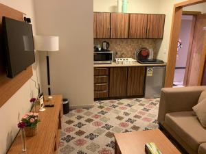 a living room with a couch and a kitchen at Altelal Apartment in Makkah