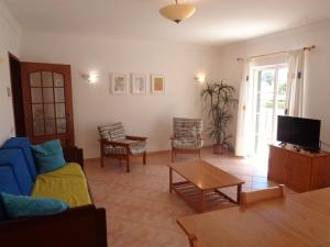 a living room with a blue couch and a table at Apartamento Citimar in Vilamoura