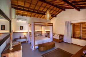 a bedroom with a canopy bed in a room at Pousada Recanto do Arraial in Arraial d'Ajuda