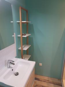 a bathroom with a white sink and a mirror at Sous les pins in Nages-et-Solorgues