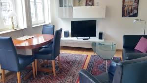 a living room with a table and a tv at ALTSTADTGLÜCK - inklusive Privatparkplatz! in Lüneburg