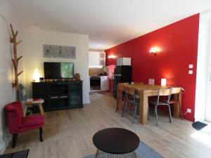 a living room with a table and a red wall at Le Clos De Quintaine Gîtes de Charme in Clessé
