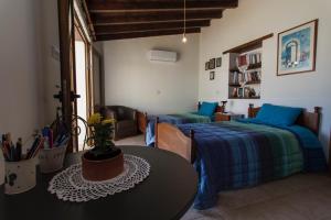 Un dormitorio con 2 camas y una mesa en una habitación en Samareitidos Light Cottage en Anaphotia
