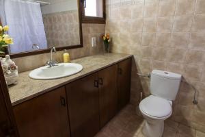 a bathroom with a toilet and a sink and a mirror at Samareitidos Light Cottage in Anaphotia