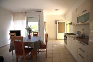uma cozinha com uma mesa e uma sala de jantar em Apartmani Marino em Vinišće