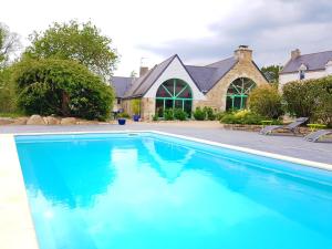 uma piscina em frente a uma casa em Domaine de Keryargon, Chambres d'hôtes em Belz