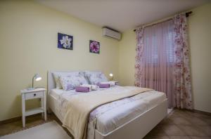 Un dormitorio con una cama grande y una ventana en Apartments Ella, en Rovinj