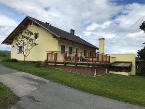ein gelbes Haus mit seitlicher Terrasse in der Unterkunft Beerenthal in Karnberg