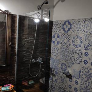 a shower in a bathroom with blue and white tiles at El Bodegón Hostal Boutique in Punta Del Diablo