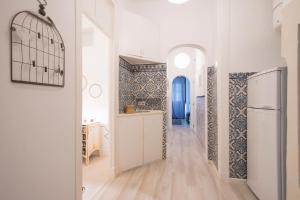 a hallway with a white refrigerator and a kitchen at Trendy Alcantara Apartment in Lisbon